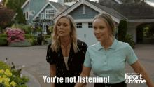 two women standing in front of a house with the words " you 're not listening " on the bottom