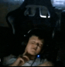 a man is laying in a chair with headphones on .