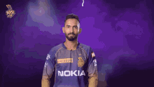 a man in a nokia jersey stands in front of a dark background