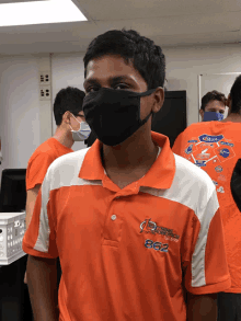 a man wearing a mask and an orange shirt that says 863