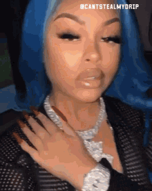 a woman with blue hair wearing a watch and a necklace