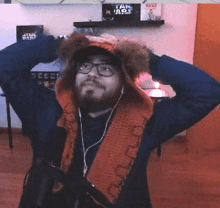 a man wearing a hooded scarf and glasses is standing in front of a shelf with star wars books on it