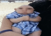 a baby with a bald head is being held by a person .