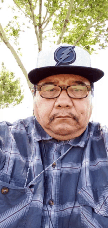 a man wearing a hat with a lightning bolt on it takes a selfie