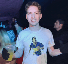 a young man wearing a t-shirt with a picture of a soccer player on it