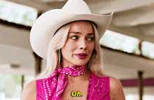 a woman wearing a white cowboy hat and a pink shirt says " oh "