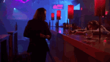 a man is standing in a dark room in front of a bar