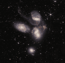 a cluster of galaxies in the night sky with a star in the middle