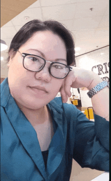 a woman wearing glasses and a watch is sitting at a table