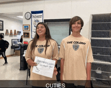 a boy and a girl wearing the colony shirts are standing next to each other