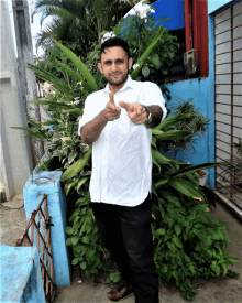 a man in a white shirt is giving a thumbs up sign