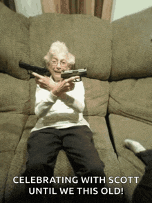 an elderly woman is sitting on a couch holding a gun with the words celebrating with scott until we this old