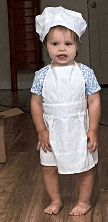 a little girl in an apron and chef hat