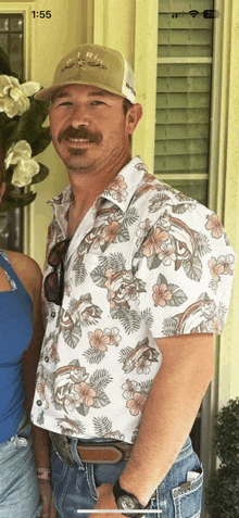 a man wearing a hawaiian shirt and a hat stands in front of a woman