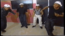 a group of men are dancing together in a room wearing hats .