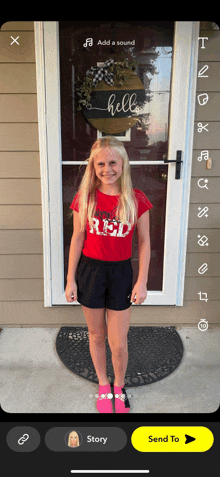 a girl wearing a red shirt and black shorts is standing in front of a door