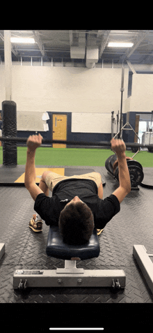 a man is laying on a bench with a barbell in his hands