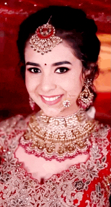 a woman wearing a necklace and earrings smiles for the camera