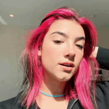 a girl with pink hair and a blue choker