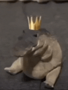 a stuffed animal is wearing a crown on its head .