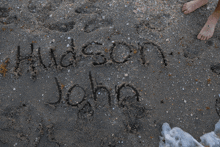 the name hudson john is written in the sand