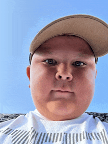 a young boy wearing a hat and a striped shirt