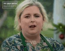 a woman in a green apron says livid in front of the great british bake off logo