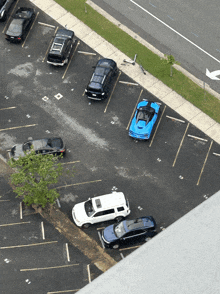 a blue car is parked in a parking lot with other cars