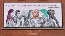 a billboard on a brick wall says a society can never be free without women 's liberation