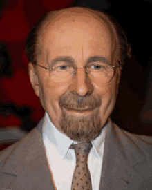 a close up of a man wearing glasses and a suit