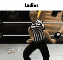 a referee is dancing in a wrestling ring with the words ladies written above him .