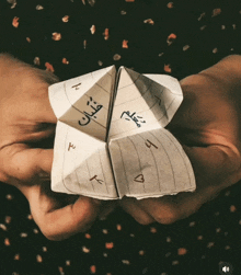 a person is holding an origami fortune teller in their hands