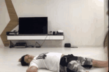 a man laying on the floor in front of a tv