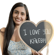 a woman holds up a heart shaped sign that says i love you kalebh