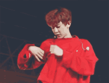 a young man wearing a red sweater is dancing