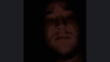 a close up of a man 's face in a dark room