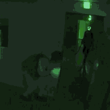 a man is standing in a room filled with boxes and a green light behind him