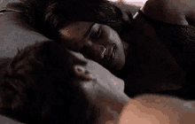 a man and a woman are laying on top of each other in bed .