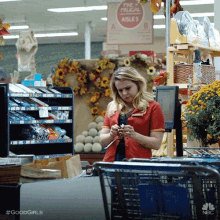 a woman in a red shirt is standing in front of a sign that says " the frugal aisle "