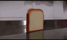 a slice of bread is sitting on a counter top .