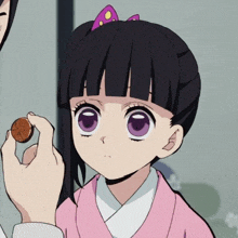 a girl with black hair and purple eyes is holding a coin