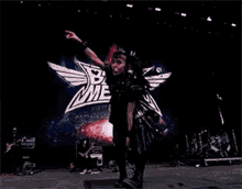 a girl in a black dress is dancing on a stage in front of a sign that says babymetal .