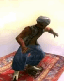 a man in a turban is dancing on a rug