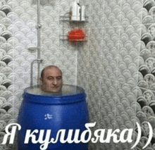 a man 's head is in a blue barrel with russian writing on the wall behind him