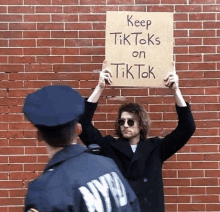 a man is holding up a sign that says keep tiktoks on tiktok