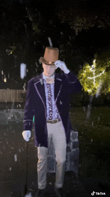 a man in a purple jacket and top hat is standing in the rain