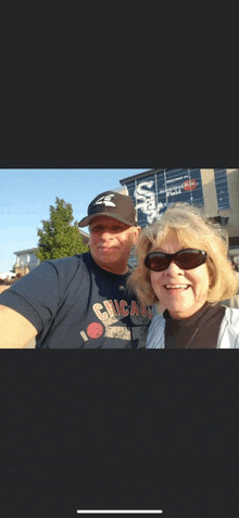 a man and a woman are posing for a picture in front of a building .