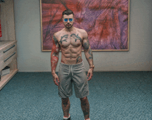 a shirtless man with tattoos on his chest and arms stands in front of a framed picture