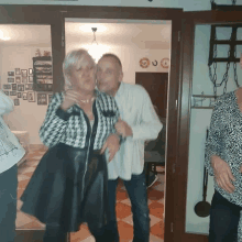 a man and a woman are dancing in a room with plates on the wall including one that says ' a ' on it