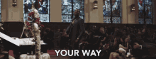 a man stands in front of a coffin in a church with the words " your way " below him